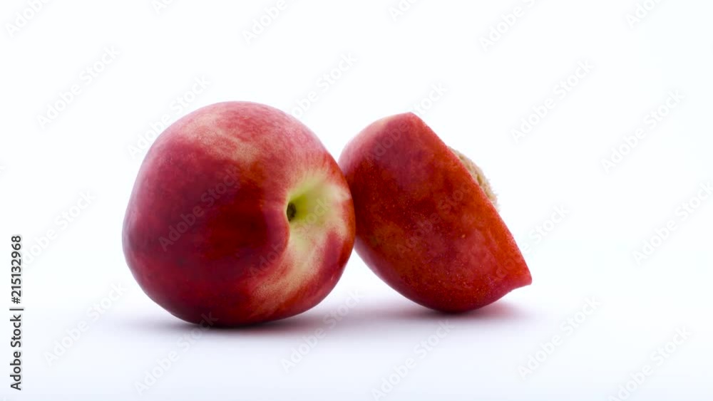 One and the half of nectarine fruit. Rotating on the turntable. Isolated on the white background. Close up. One and the half of nectarine fruit. Rotating on the turntable. Isolated on the white background. Close up.
