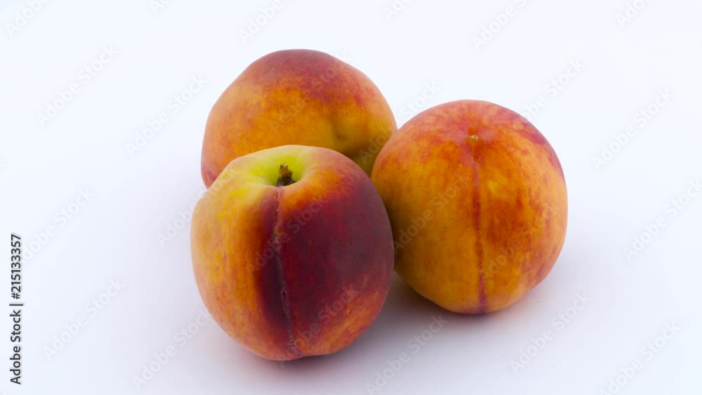 Three peach fruits. Rotating on the turntable. Isolated on the white background. Close up. Three peach fruits. Rotating on the turntable. Isolated on the white background. Close up.