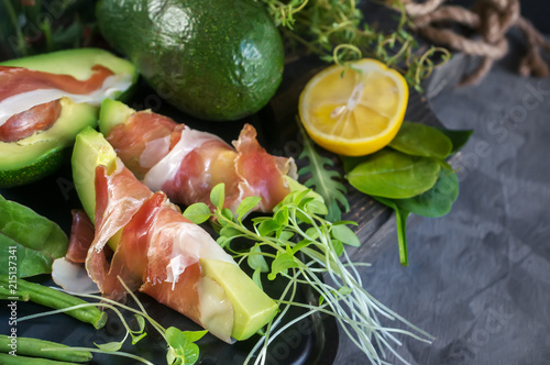 Delicious toasts of avocado and prosciutto with green sprouted mustard photo