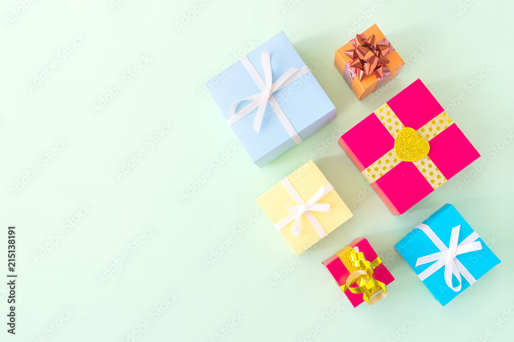 Different colored gift box on pastel light green background. Top view of various present boxes on minimal background. Birthday, Christmas, wedding, valentine, romantic gifts Different colored gift box on pastel light green background. Top view of various present boxes on minimal background. Birthday, Christmas, wedding, valentine, romantic gifts