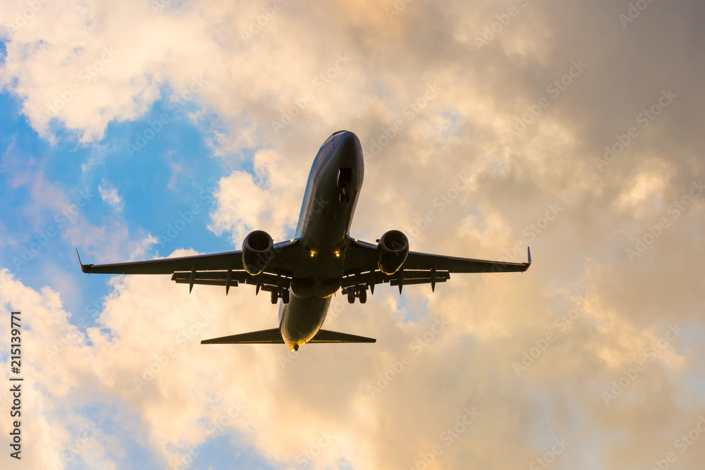 Fototapeta premium Dark silhouette of an airplane at sunset approach in the airport of a beautiful beautiful sky.