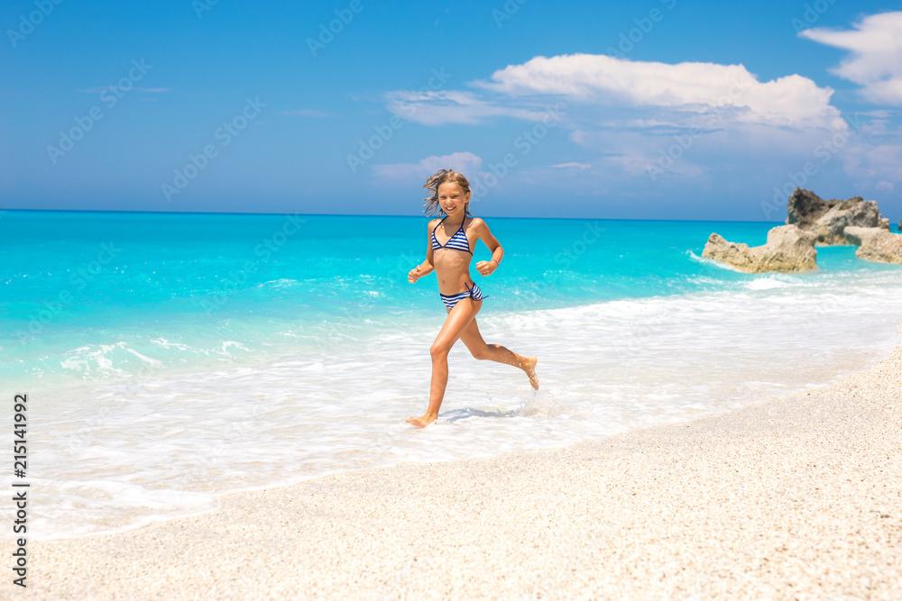 Beautiful little girl running on the beach