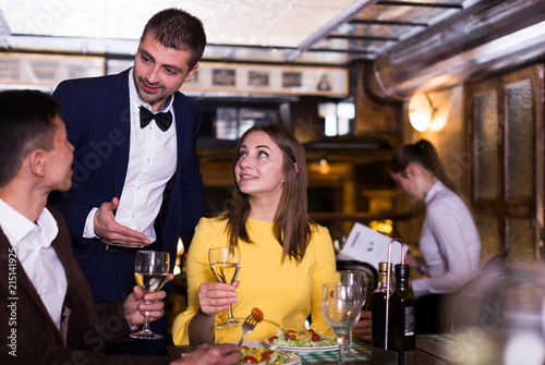 Man administrator is interesting in quality of service from couple who have dinner