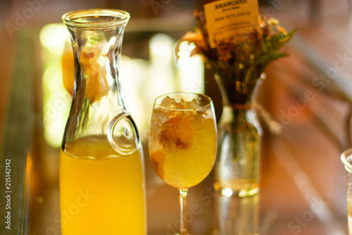 carafe with wine sangria and fruit with glass vase with flowers