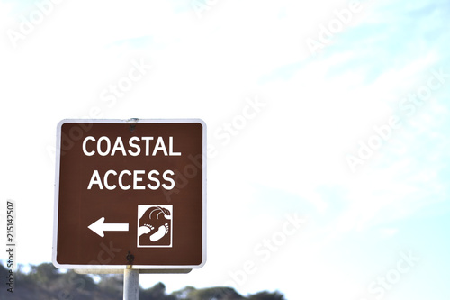 Coastal access sign with arrow beach sunny summer