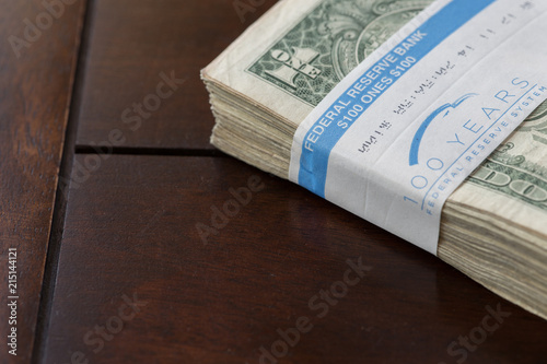 A stack of dollar bills wrapped in federal reserve paper