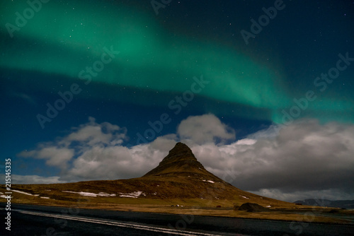 Northern lights aurora borealis appear over Mount Kirkjufell in Iceland.