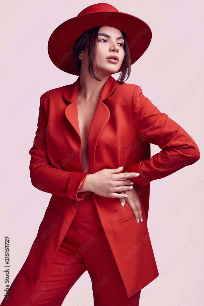 Elegant beautiful woman in a red fashionable suit and wide hat Stock Photo