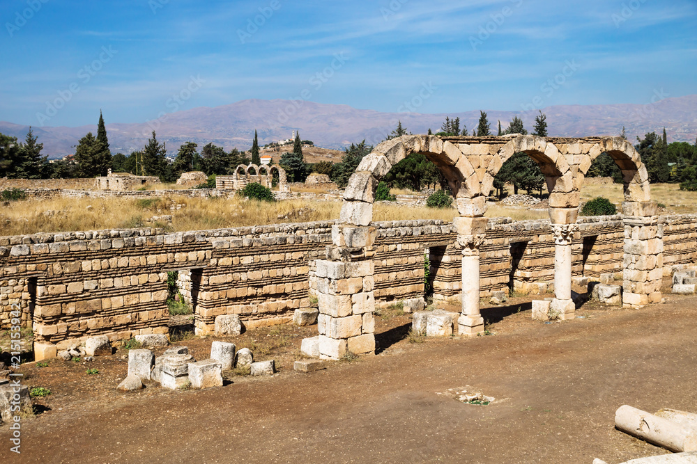 Arches in Umayyad city ruins in Anjar with mountains, Bekaa valley, Lebanon