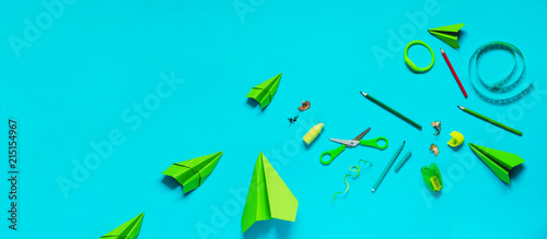 stationery set. everything is picked up in green on a blue background. scissors, pencils, watch, airplane, scotch, paper, a grinder