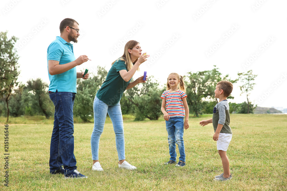 Happy family playing together with their children outdoors Happy family playing together with their children outdoors