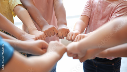Little children putting their hands together, closeup. Unity concept
