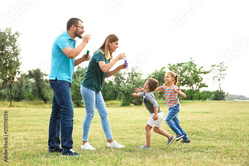 Happy family playing together with their children outdoors