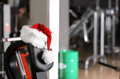 Santa Claus hat on modern exercise machine in gym