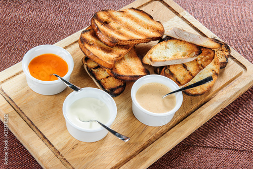 Different sauces with toasted bread. photo