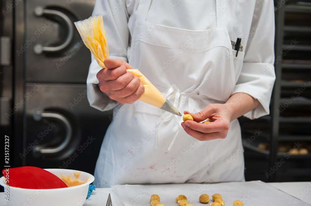 Chef piping filling into pastry Chef piping filling into pastry