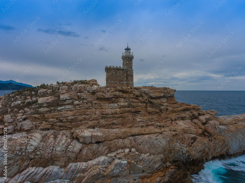 Ancient lighthouse on a rock in the sea.