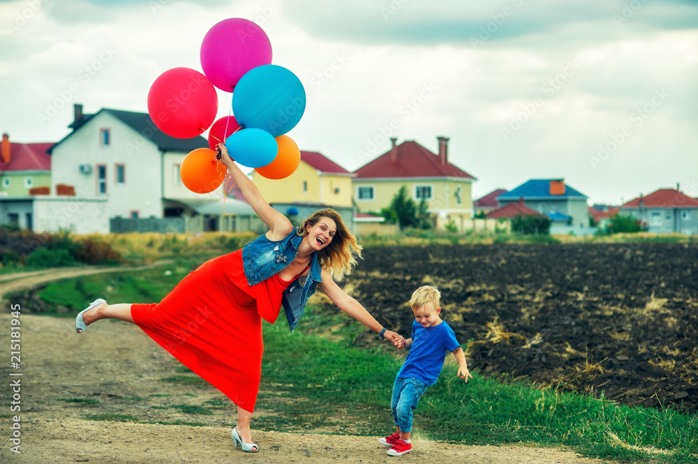 Happy loving family having fun on the walk .  Young mother and son play in the summer on a country walk with balloons