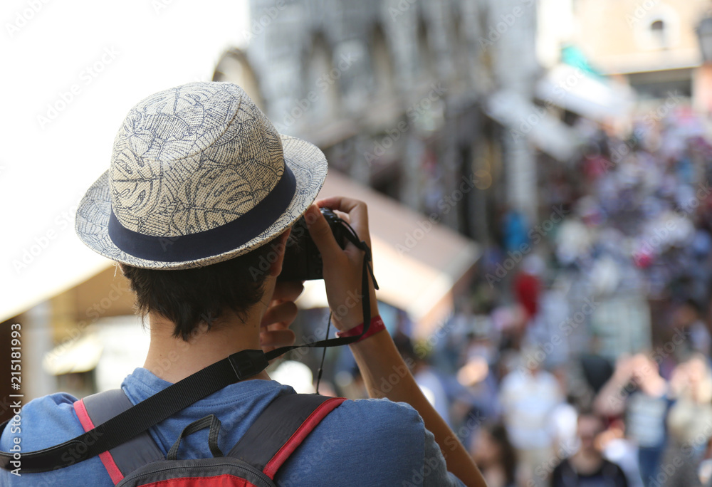 Young photographer with hat on Rialto Bridge in Venice Italy