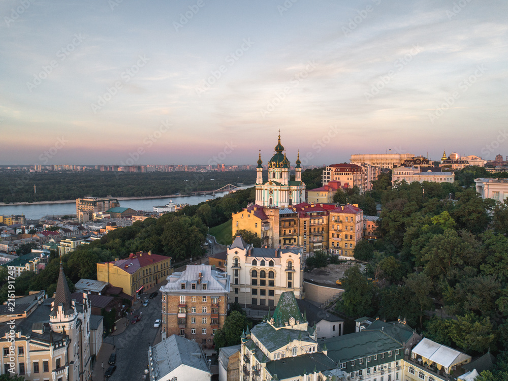 Panorama of the city of Kiev with the domes of St. Andrew's Church in the foreground, the historic district of Podol and the Dnieper River in the background. Aerial view