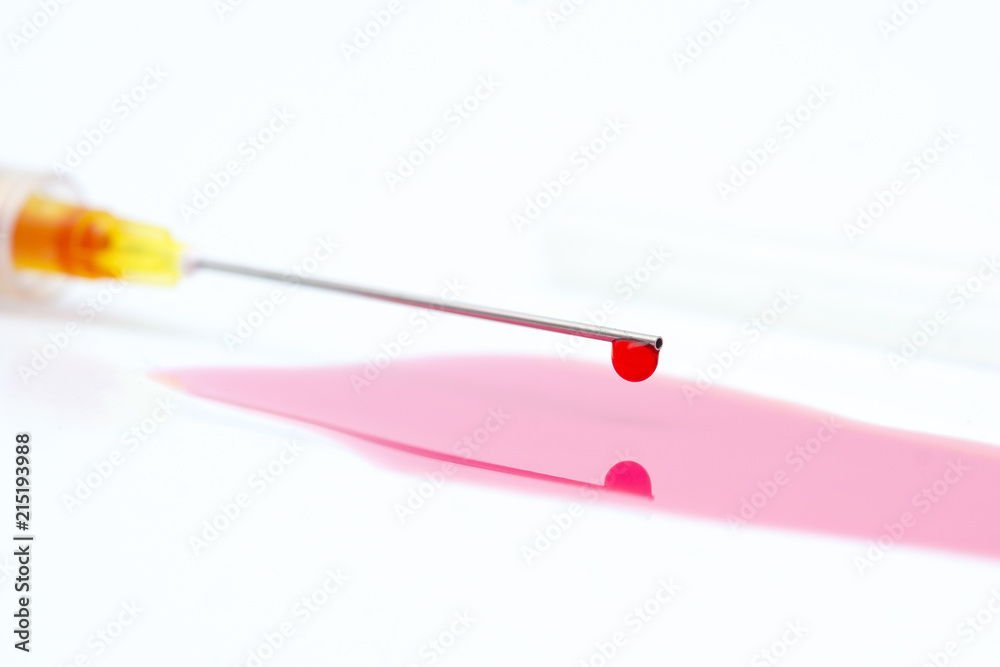 close up blood drip from the tip of the needle