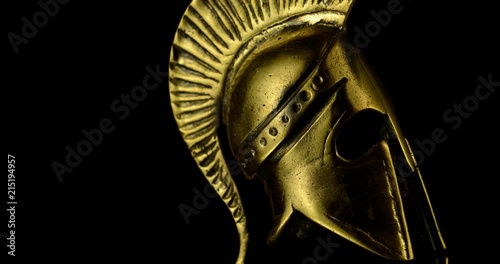 A wonderful golden Spartan helmet as part of the equipment of ancient greek soldiers. King Leonidas and his 300th The piece of metal stands against a black background