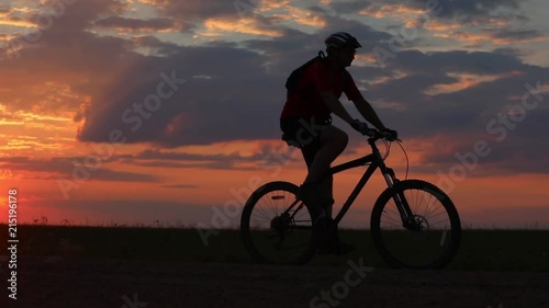 Wallpaper Mural Silhouette of a bicyclist traveling on a sunset background on the road to the field Torontodigital.ca