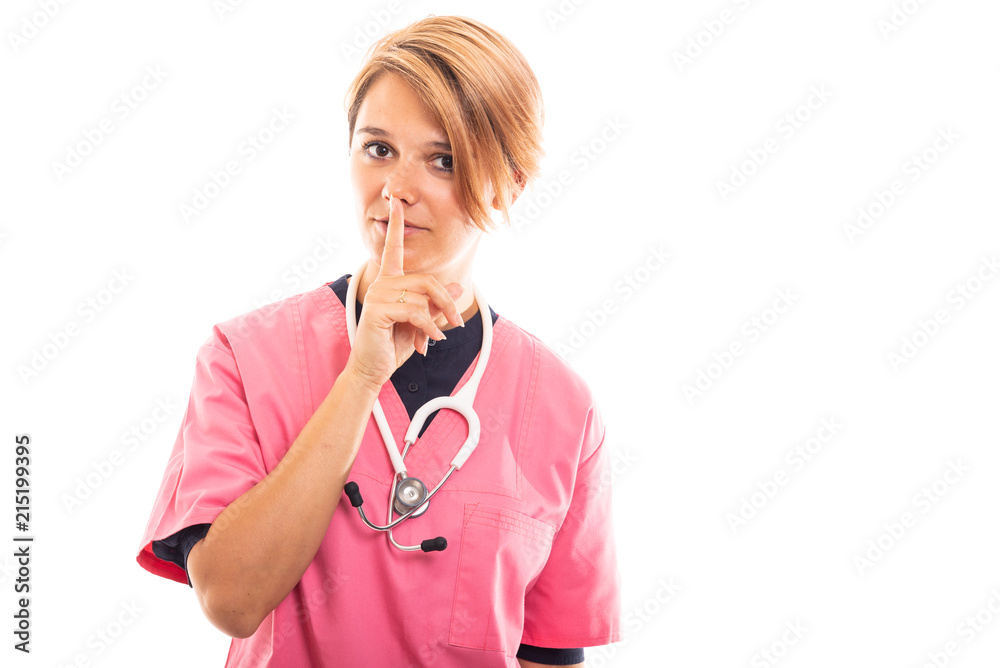 Portrait of female vet wearing pink scrub showing silence gesture. Portrait of female vet wearing pink scrub showing silence gesture.