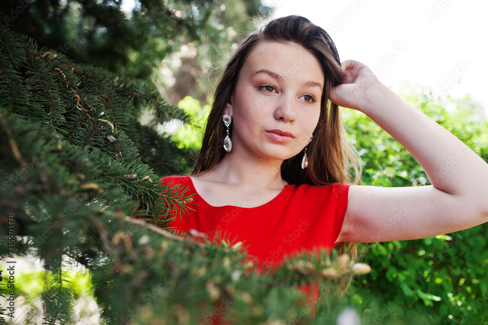 Teenage girl in red dress posed outdoor at sunny day. Teenage girl in red dress posed outdoor at sunny day.