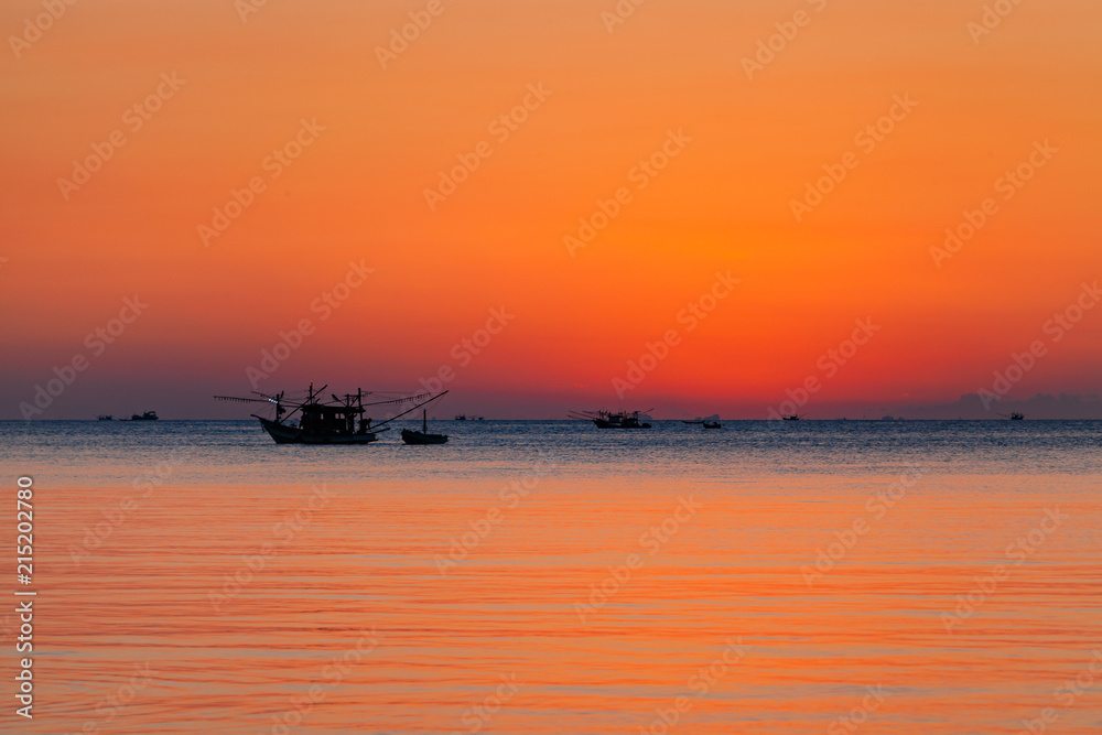Beautiful sunset with fishing boat and sea.