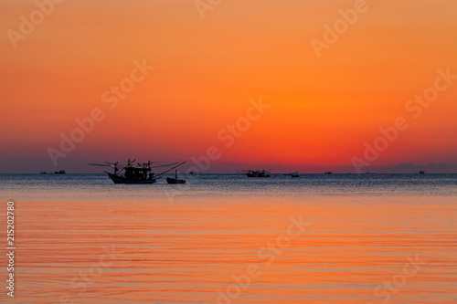 Beautiful sunset with fishing boat and sea.