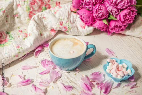 Coffee with milk and flowers pink peonies. The atmosphere of relaxation.   