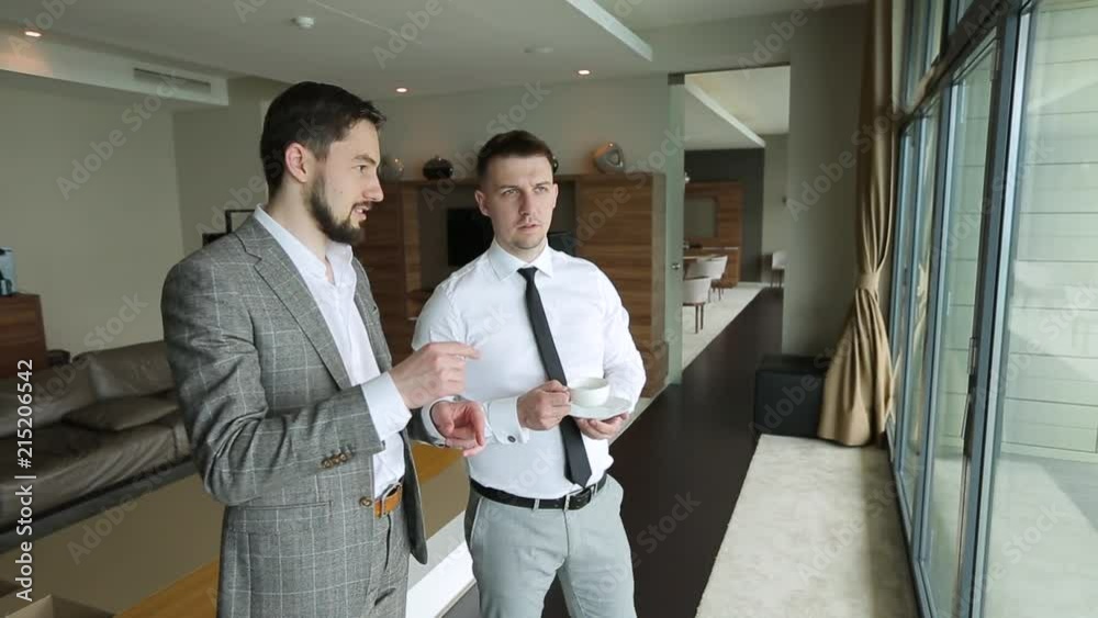 Two businessmen are discussing plans for today over a Cup of coffee