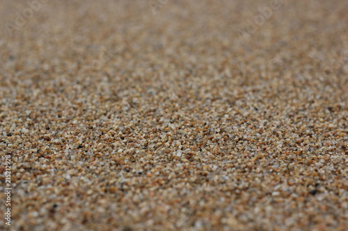 Closeup brown sandy beach background. Blurred lake Baikal gravel for textures, travel banner design