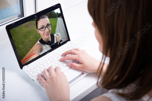 young woman watching video blog on laptop