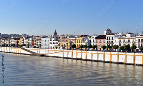 Colorful houses underneath a blue sky by the Guadalquivir river in Seville, Spain photo