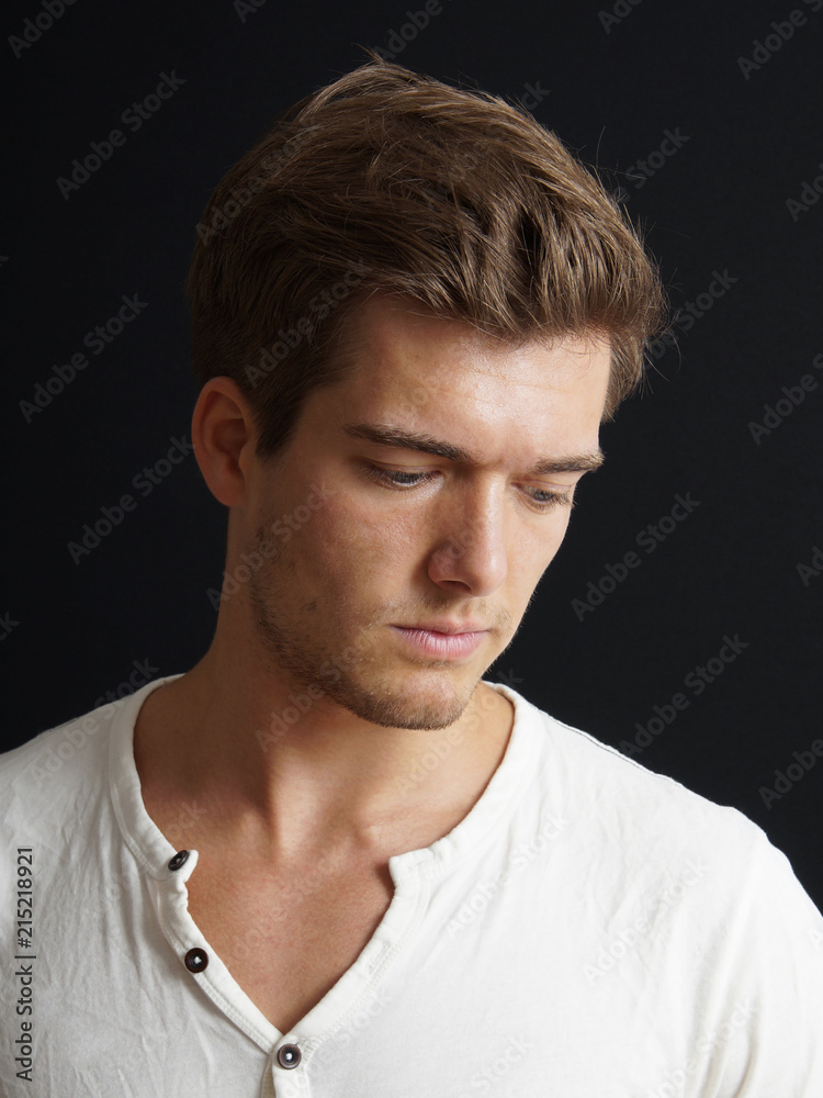 Obraz premium introverted young man looking down on black