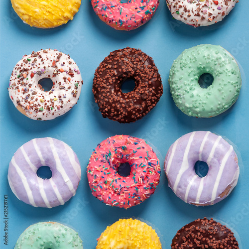 Pastel blue background filled with colorful donuts