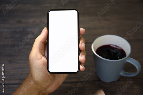 Male hands holding phone with isolated screen over the table