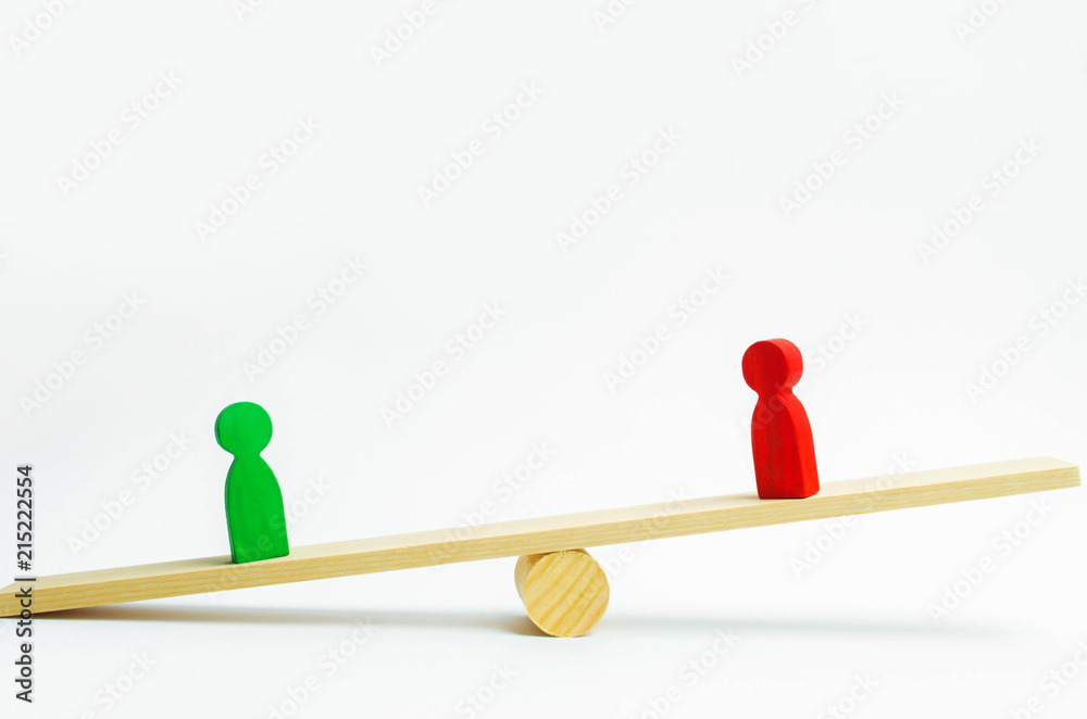 wooden figures of people. rivals in business stand on the scales. trial. conflict. victory and defeat. bad and good worker. the red figure outweighs the green one. concept of success and power. wooden figures of people. rivals in business stand on the scales. trial. conflict. victory and defeat. bad and good worker. the red figure outweighs the green one. concept of success and power.