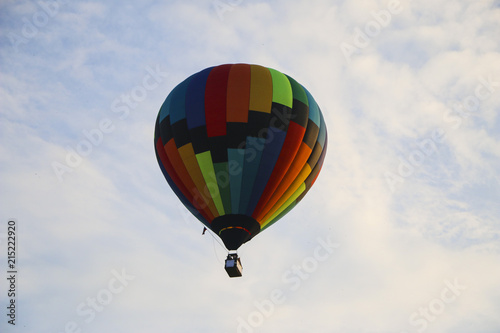 colorful hot air balloon against blue sky. hot air balloon is flying in white clouds. beautiful flying on hot air balloon