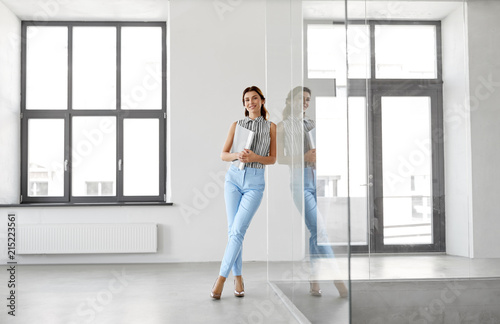 business, people and corporate concept - businesswoman or realtor with folder at office glass wall photo