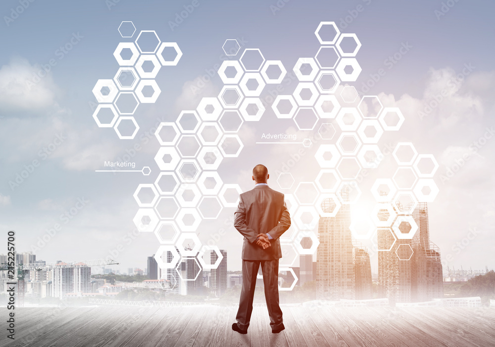 Pensive businessman looking at user interface against modern city background Pensive businessman looking at user interface against modern city background