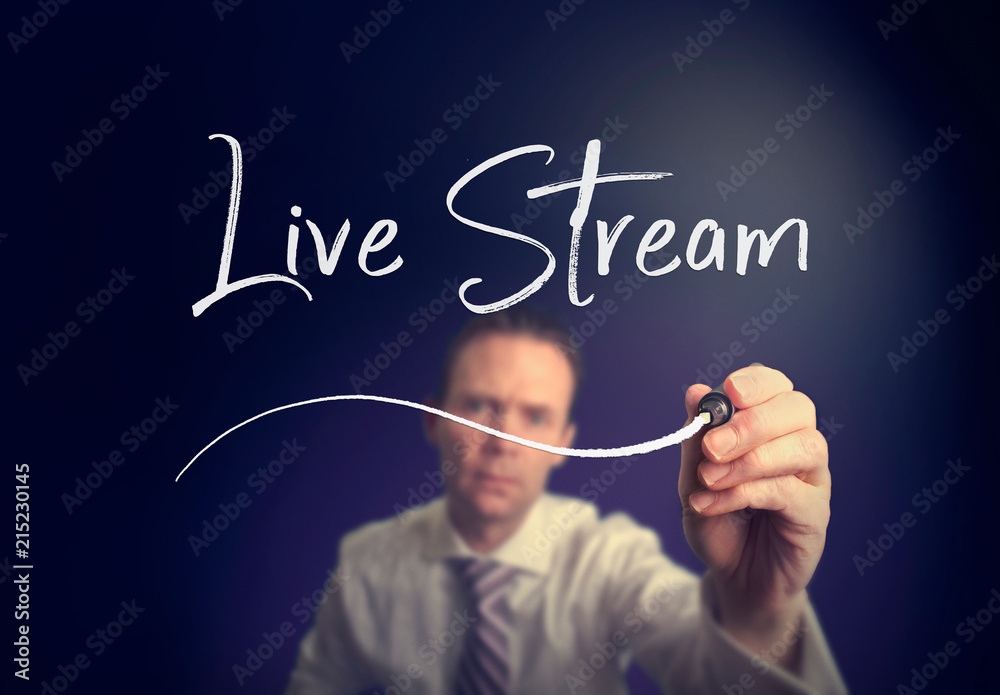 A businessman writing a live stream concept with a white pen on a clear screen. A businessman writing a live stream concept with a white pen on a clear screen.