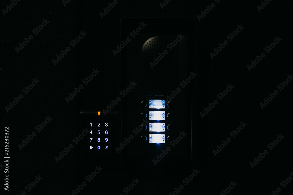 Close-up. The intercom at the entrance to the residential building in the night. Means of communication or notification of arrival and security of the entrance inside.