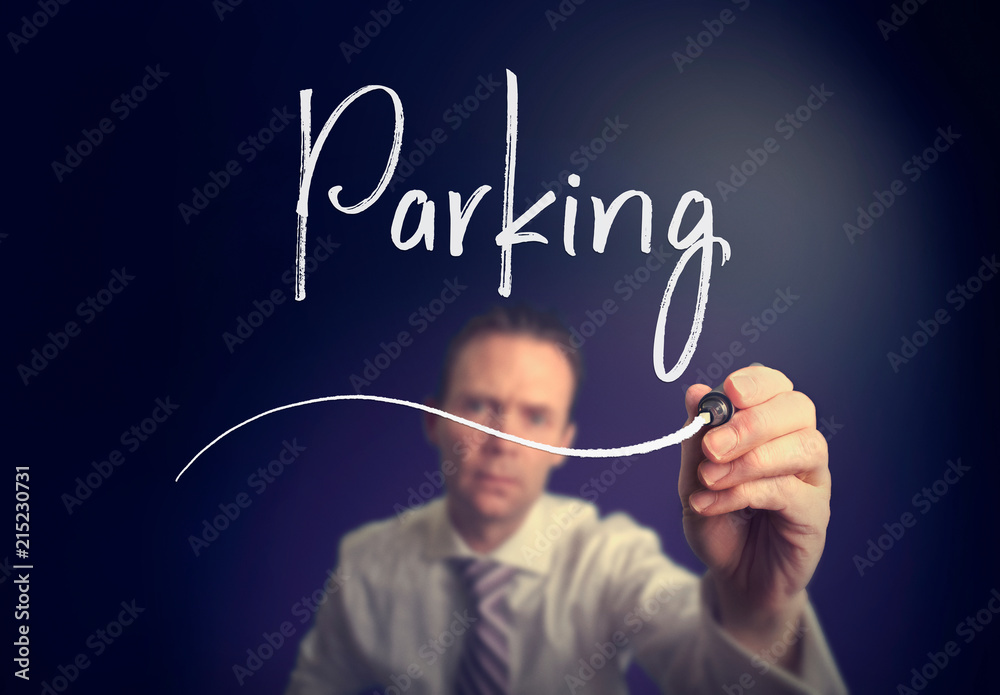 A businessman writing a parking concept with a white pen on a clear screen. A businessman writing a parking concept with a white pen on a clear screen.