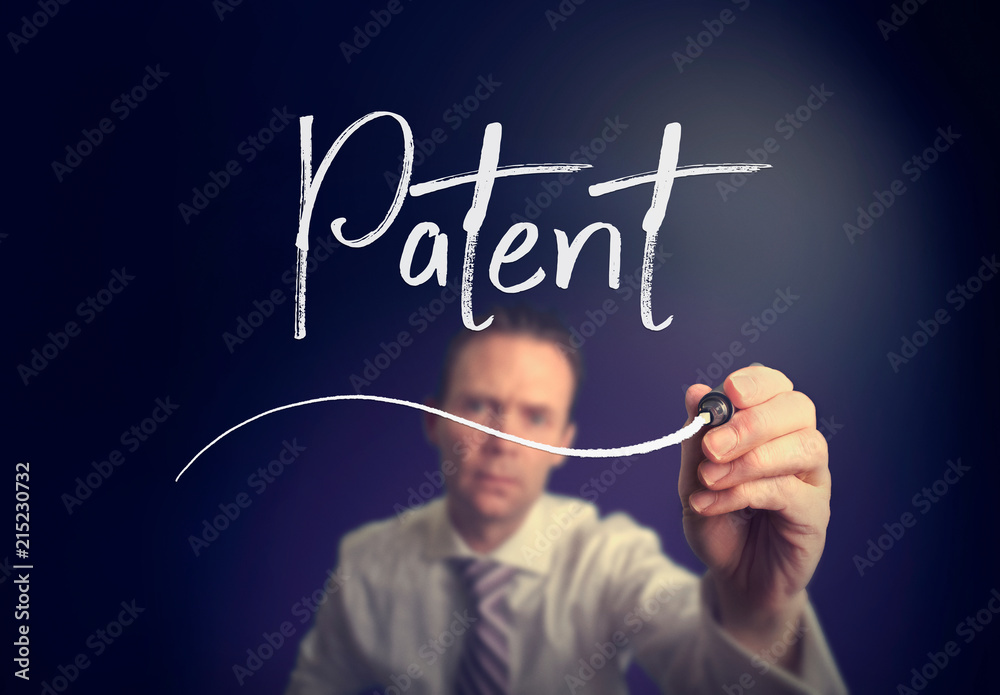 A businessman writing a patent concept with a white pen on a clear screen. A businessman writing a patent concept with a white pen on a clear screen.