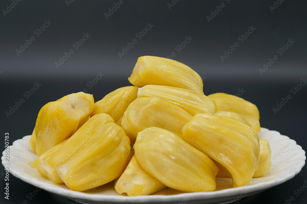 Fresh jackfruit slices on a white plate. sweet yellow jackfruit ripe. vegetarian, vegan, raw food. Exotic tropical fruit - isolated