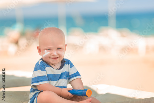 Cute baby boy with sunscreen on