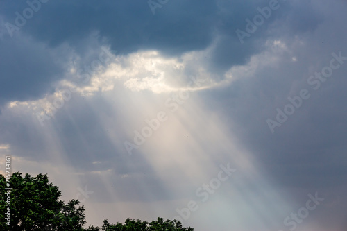 Rays of lights coming through dark clouds just before heavy rain  divine light from heaven